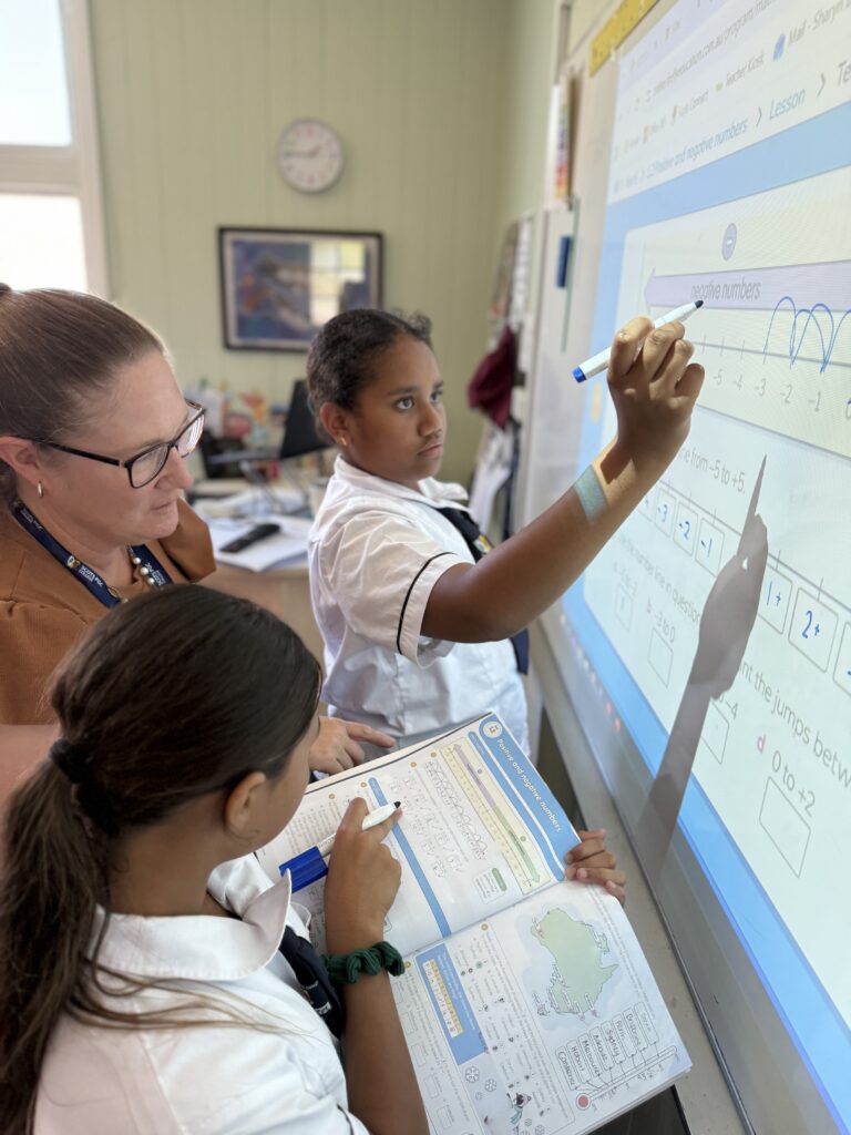 Sharyn and students working with the interactive whiteboard.