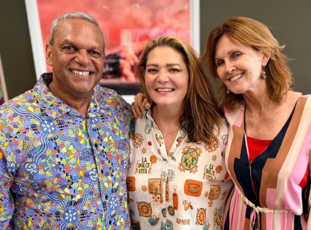 Three adults smiling at the camera standing close together indoors for a casual group photo   yalari   yalari